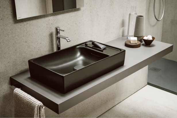 Ein modernes Badezimmer mit einem schwarzen, rechteckigen Waschbecken und Armaturen.