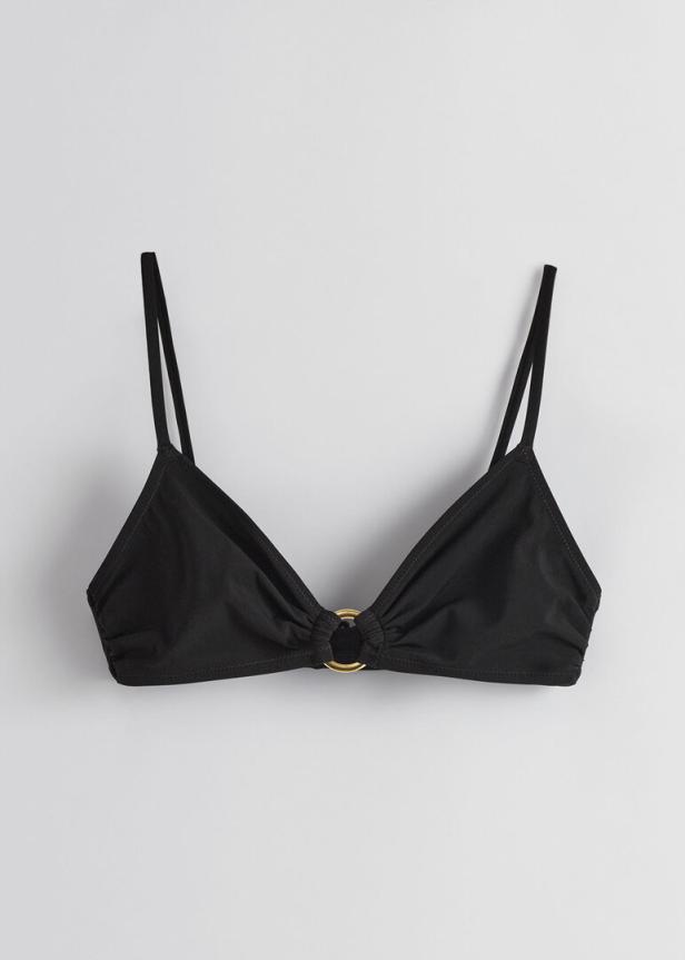 Ein schwarzes Triangel-Bikini-Oberteil mit einem goldenen Ring in der Mitte.
