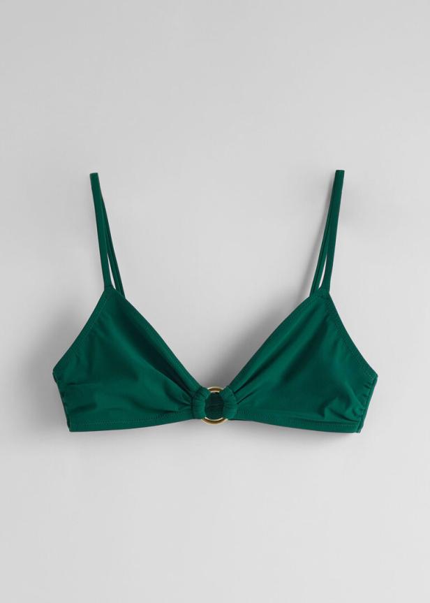 Ein grünes Triangel-Bikini-Oberteil mit goldenem Ringdetail vor einem weißen Hintergrund.