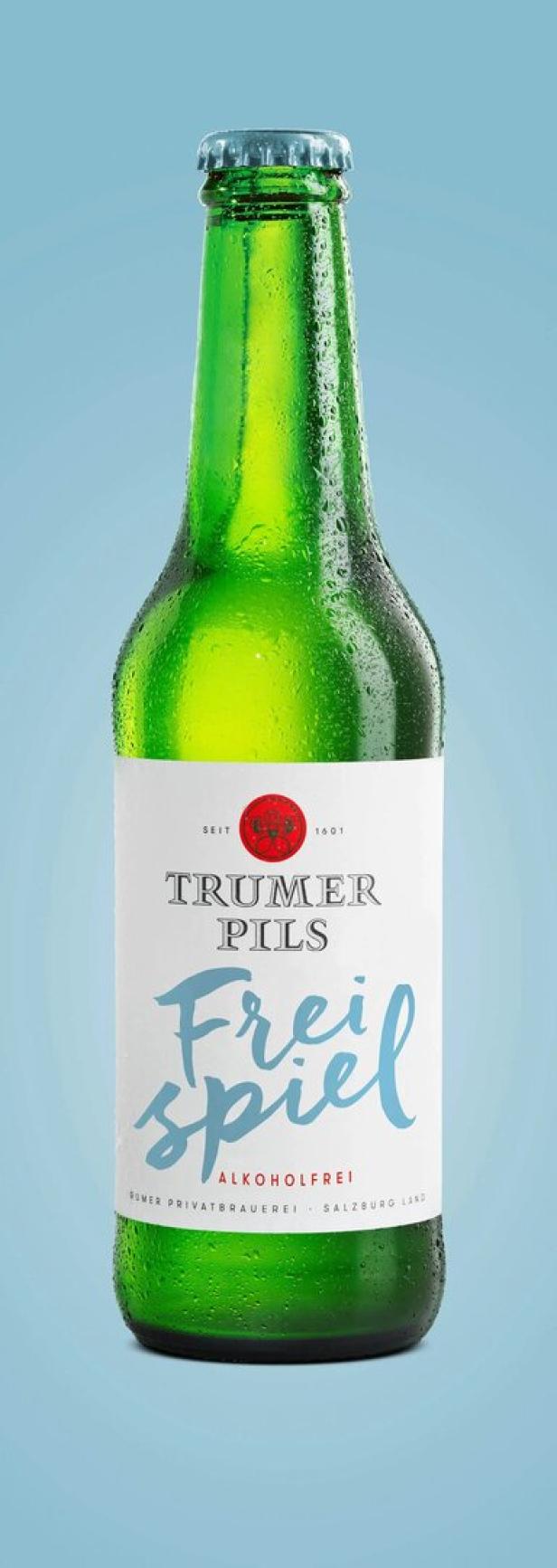 Eine grüne Flasche Trumer Pils „Freispiel“ alkoholfrei vor hellblauem Hintergrund.