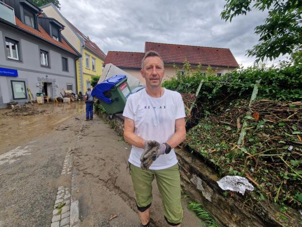 Mann räumt Unwetterschäden auf