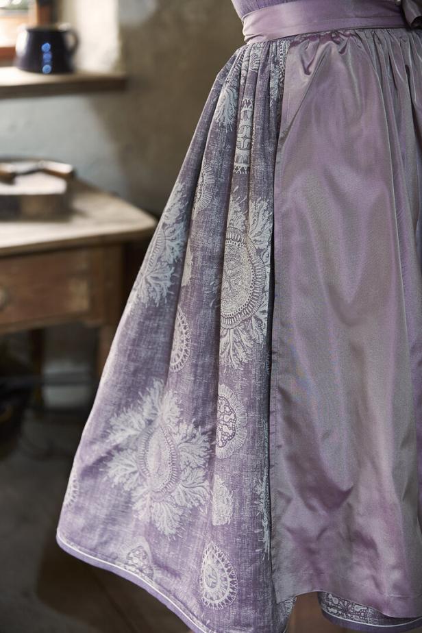 Detailaufnahme eines lilafarbenen Dirndls mit floralem Muster.