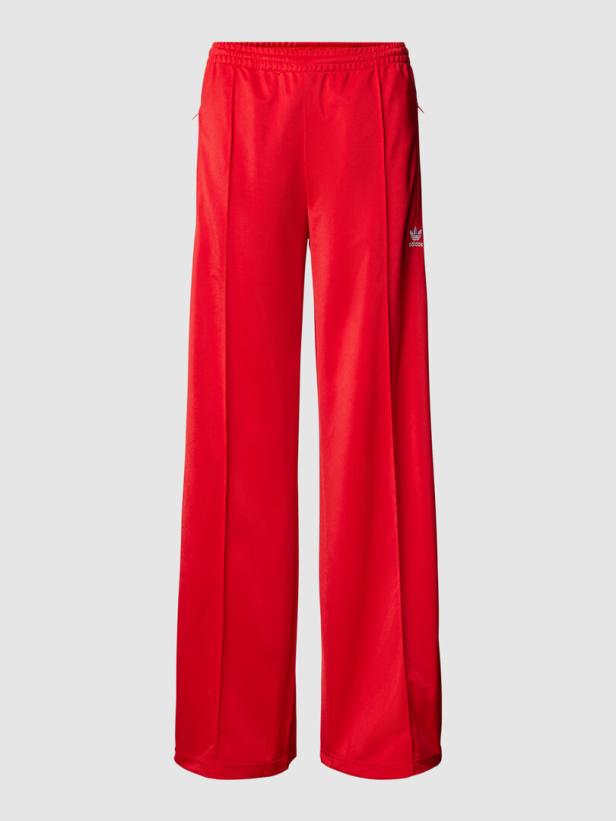 Eine rote Adidas-Hose mit weitem Bein und seitlichem Logo.