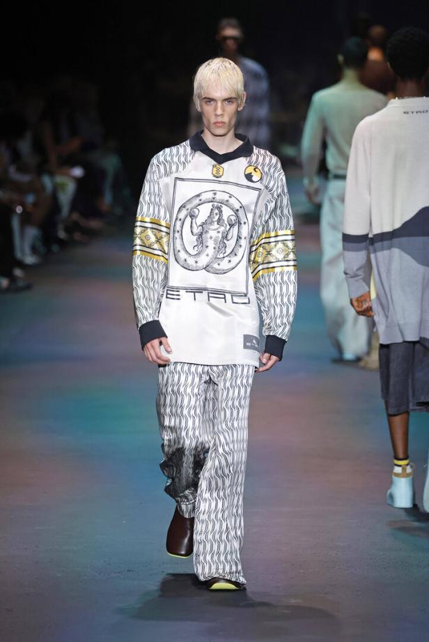 Ein Model präsentiert ein weißes Etro-Ensemble mit grafischen Mustern auf einem Laufsteg.