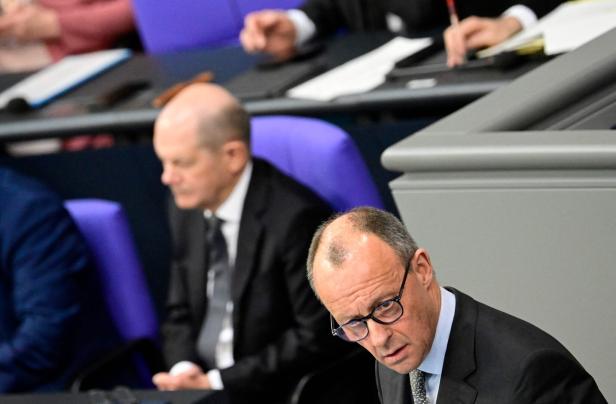 Merz und Scholz im Hintergrund im Bundestag.