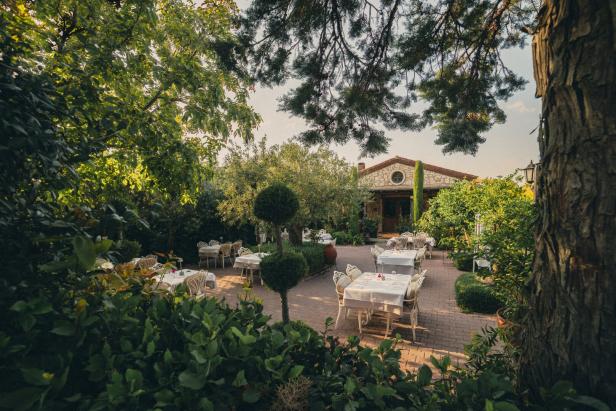 Ein Restaurantgarten mit gedeckten Tischen und üppigem Grün.