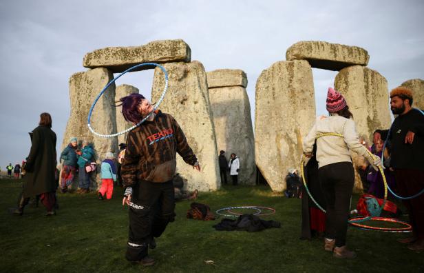 Menschen spielen mit Hula-Hoop-Reifen vor den Steinen von Stonehenge.