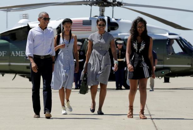 Barack Obama mit Michelle und ihren Töchtern vor einem Hubschrauber.