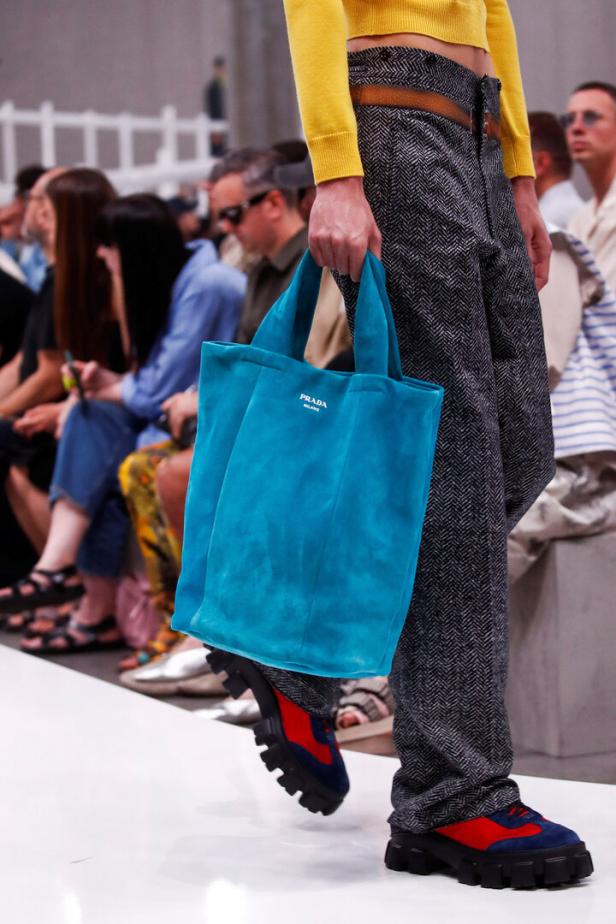 Ein Model mit einer blauen Prada-Tasche auf dem Laufsteg.