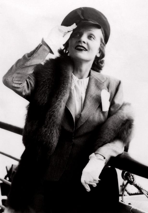 Marlene Dietrich mit Hut und Pelzstola auf einem Schiff.