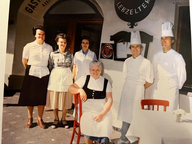 Das Personal eines Restaurants, darunter Köche und Kellnerinnen, posiert für ein Foto.