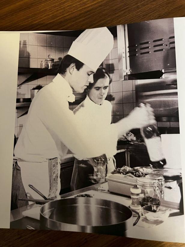 Zwei Köche bereiten Speisen in einer Restaurantküche zu.