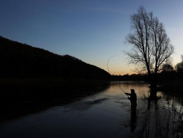 Fisherman Lee Ross casts the first line following the  Blessing of the Salmon service at Pedwell Landings in Norham