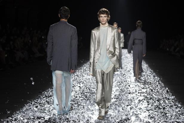 Models präsentieren Mode auf einem mit Konfetti bedeckten Laufsteg.