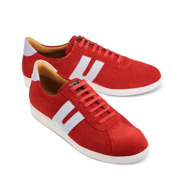 Zwei rote Wildlederschuhe mit weißen Streifen stehen auf einem weißen Hintergrund.