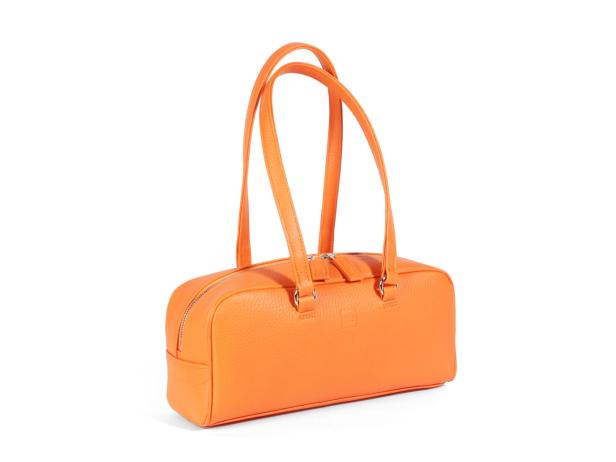 Eine orangefarbene Handtasche aus Leder mit silbernem Reißverschluss und Henkeln.