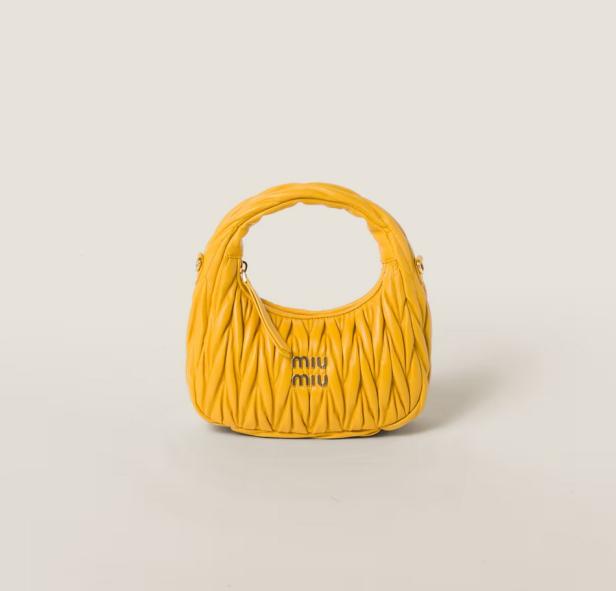 Eine gelbe Handtasche der Marke Miu Miu mit gerafftem Design.