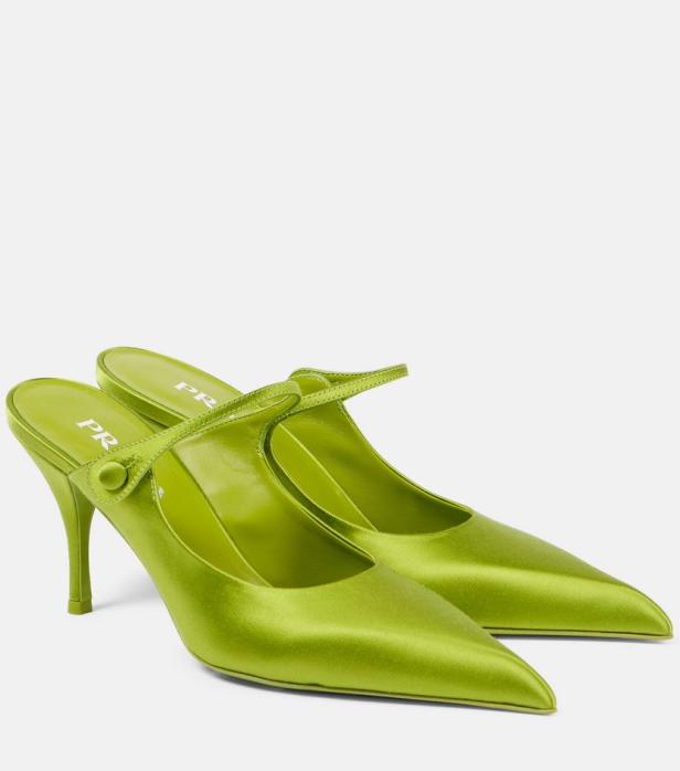 Ein Paar grüne Prada-Satin-Mules mit Absatz stehen vor einem weißen Hintergrund.