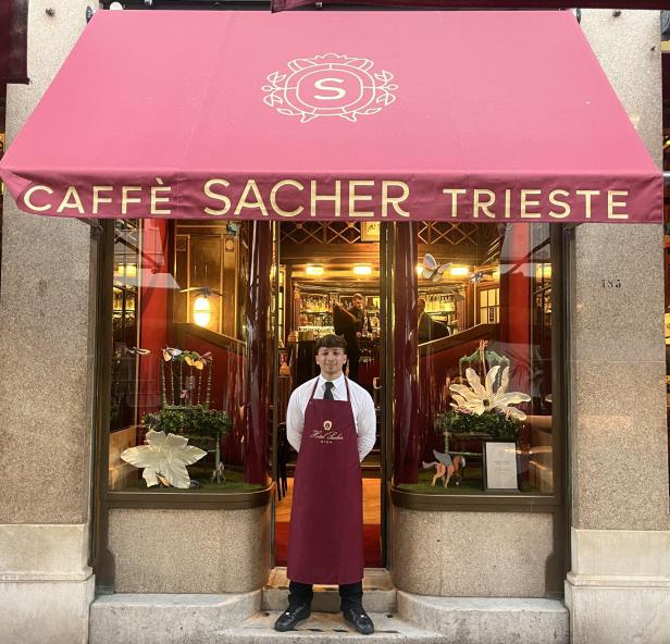 Ein Kellner steht vor dem „Caffè Sacher Trieste“.