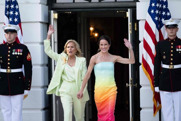 Jill Biden und eine Frau winken vor dem Weißen Haus.