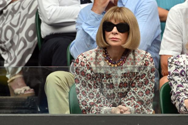 Anna Wintour mit Sonnenbrille und gemusterter Bluse bei einer Veranstaltung.