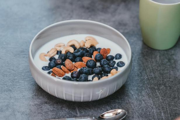 Eine Schüssel Joghurt mit Blaubeeren, Mandeln und Cashewnüssen.