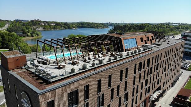 Das Winery Hotel mit Pool auf dem Dach und Blick auf einen See.