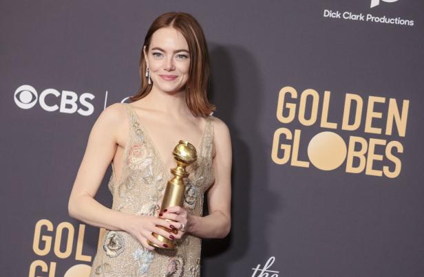 Emma Stone hält eine Golden Globe-Trophäe in den Händen.