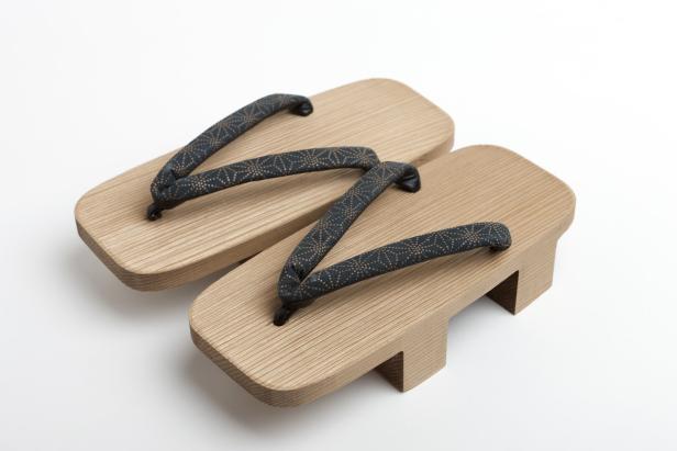 Plateau-artige Holzsandalen mit zwei Holzpföckchen auf der Sohle.