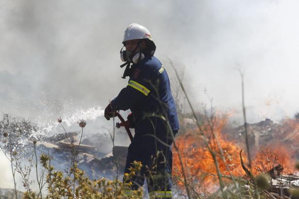 Ein Feuerwehrmann löscht einen Waldbrand südlich von Athen