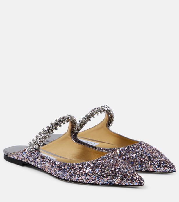 Zwei glitzernde, spitze Mules mit Strass-Verzierung stehen vor einem neutralen Hintergrund.