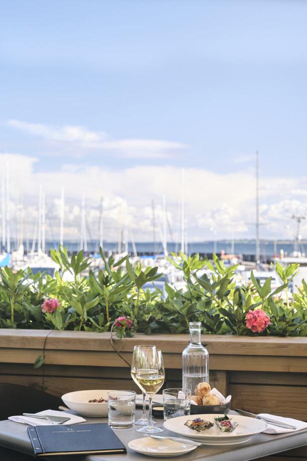 Ein gedeckter Tisch mit Blick auf einen Yachthafen.
