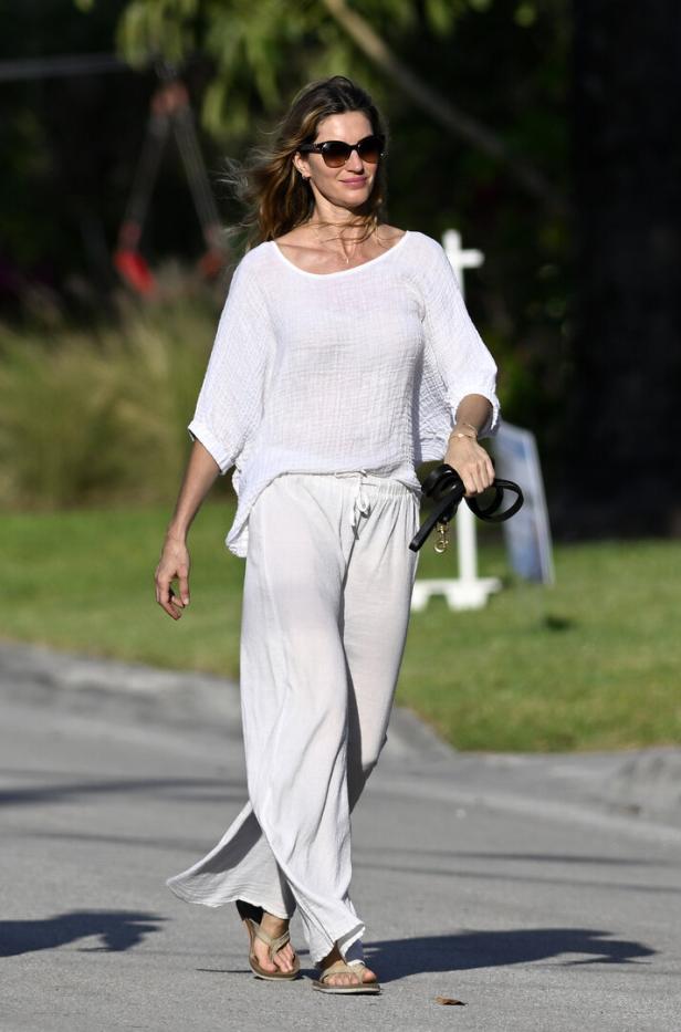 Gisele Bündchen geht mit Sonnenbrille und lässiger Kleidung spazieren.