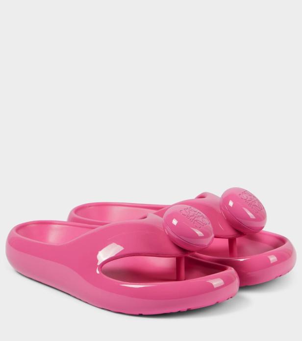 Ein Paar pinke Badesandalen mit runden Applikationen des Loewe-Logos.