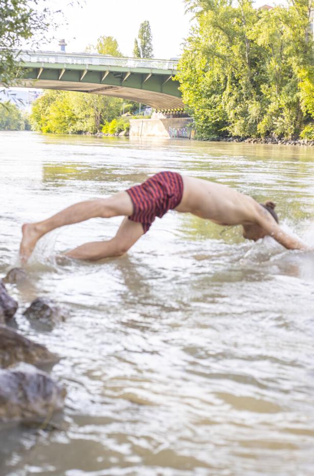 Ein junger Mann köpfelt von der Einstiegsstelle aus ins Wasser.