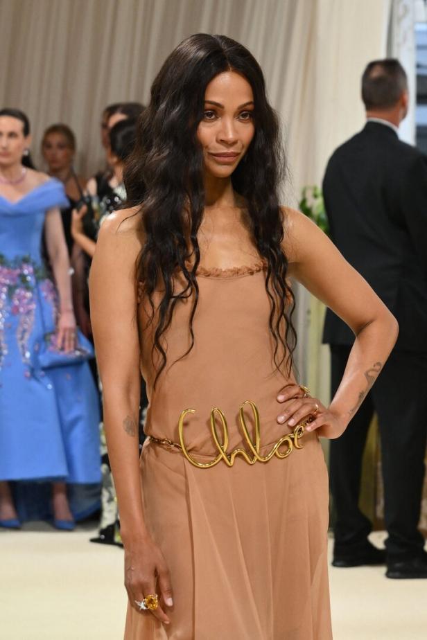 Zoe Saldana trägt ein beiges Kleid mit einem goldenen „Chloé“-Gürtel.