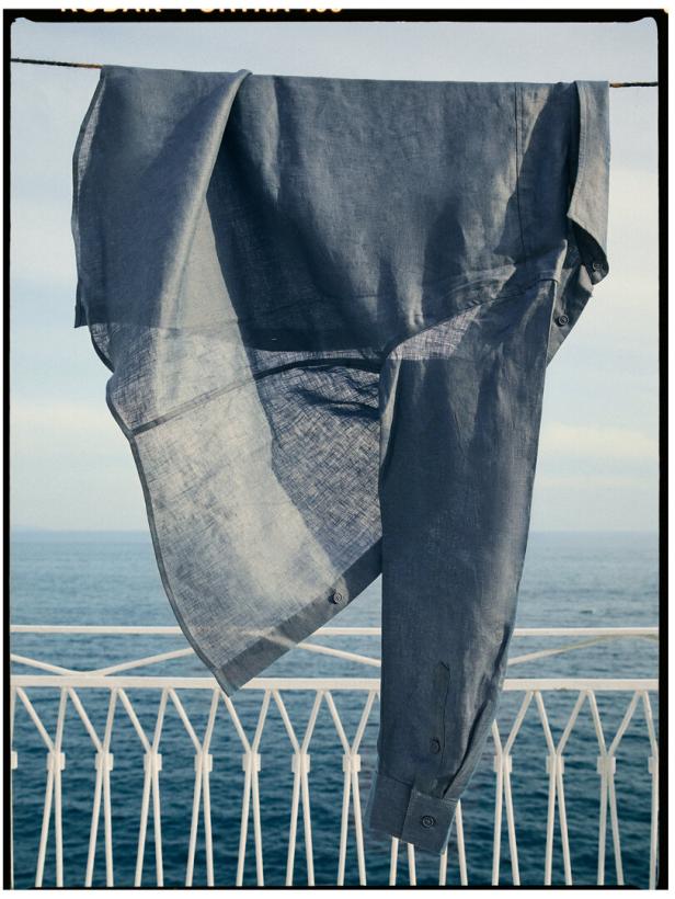 Ein blaues Hemd hängt auf einem Schiffsdeck zum Trocknen.