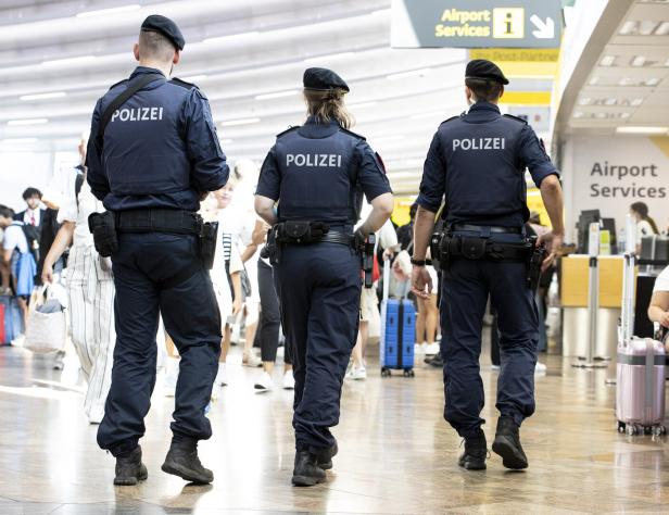 Polizisten gehen am Flughafen