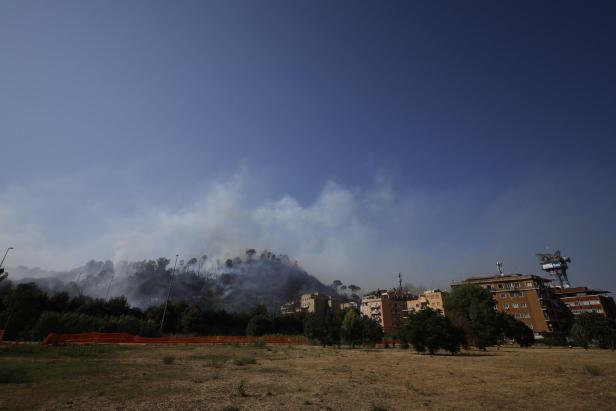 Large fire breaks out near Judicial City in Rome Rauch steigt von einem Hügel in der Nähe von Wohngebäuden auf.