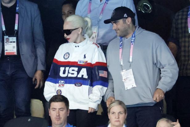 Lady Gaga trägt eine USA-Jacke bei einer Sportveranstaltung.