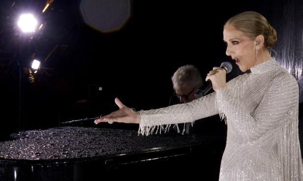 Céline Dion singt an einem Klavier, das mit Wassertropfen bedeckt ist.
