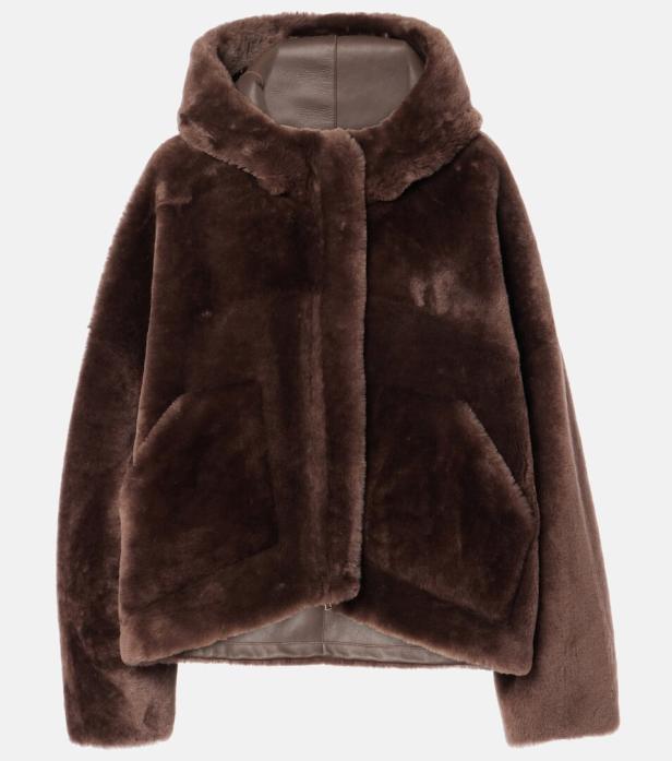 Eine braune Jacke mit Kapuze aus Teddyfell und Lederdetails.