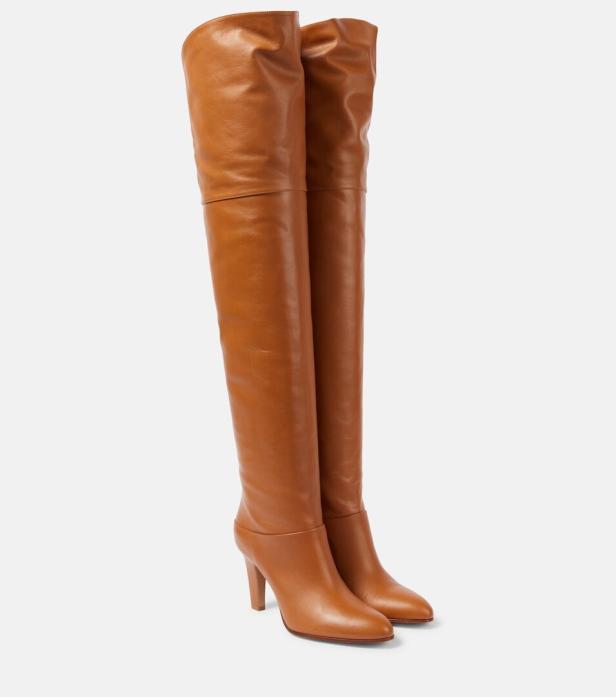 Ein Paar hohe, braune Lederstiefel mit Absatz stehen vor einem weißen Hintergrund.