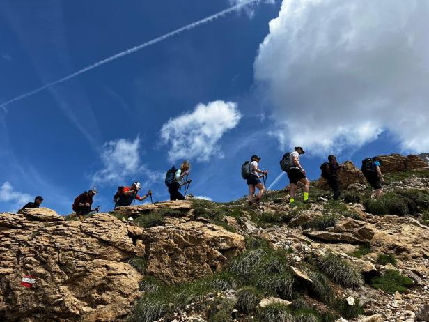 Gruppe von Bergsteigern Richtung Plattkofel in Südtirol über ein Geröllfeld