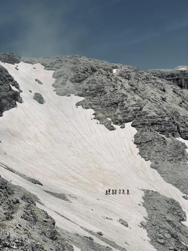 Schneefeld in den Dolomiten, eine Gruppe Bergsteiger bei der Überschreitung