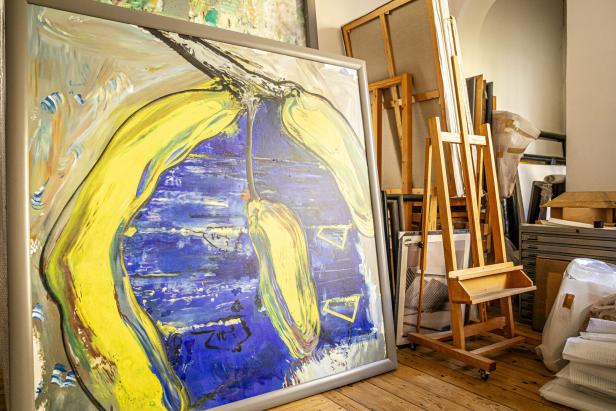 Ein abstraktes Gemälde mit gelben und blauen Farbtönen in einem Atelier.