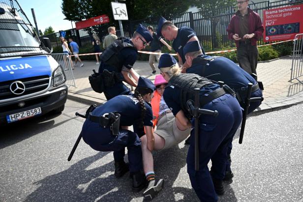 Polnische Polizisten führen eine Demonstrantin ab.