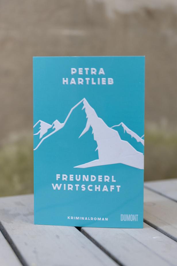 Das Cover des Kriminalromans „Freunderlwirtschaft“ von Petra Hartlieb mit einer Bergillustration.