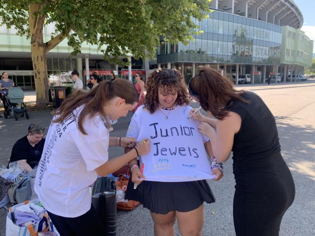 Zwei Frauen unterschreiben auf dem Shirt einer anderen Frau