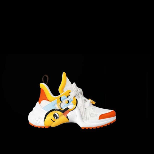 Ein weißer Louis Vuitton Sneaker mit gelben und orangen Akzenten und einem Cartoon-Entenmotiv.